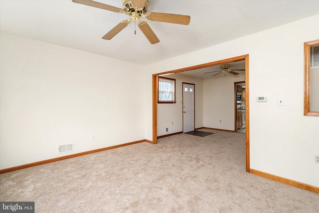 carpeted spare room featuring ceiling fan