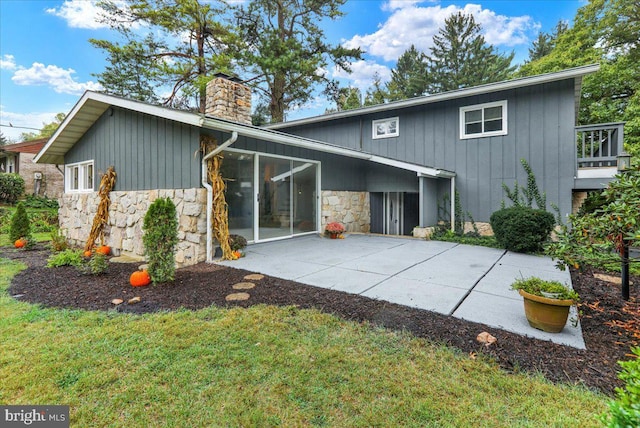 rear view of house featuring a patio and a yard