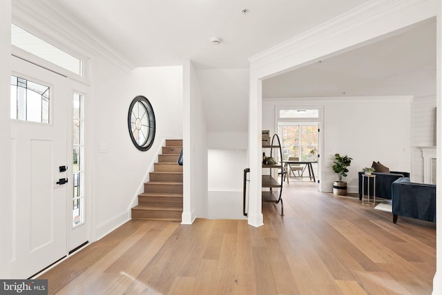 foyer with light hardwood / wood-style floors and crown molding