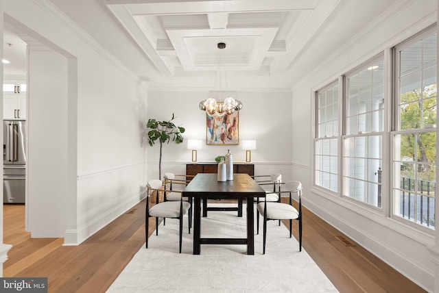 dining area featuring light hardwood / wood-style floors, crown molding, beam ceiling, and coffered ceiling