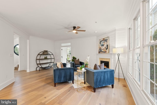 living room featuring hardwood / wood-style floors, ceiling fan, and crown molding