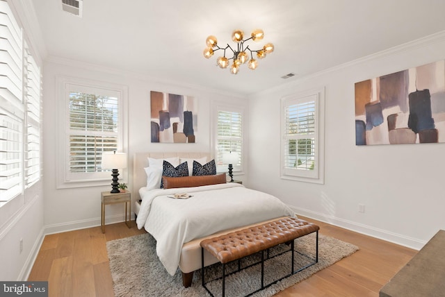 bedroom with hardwood / wood-style floors, a notable chandelier, and ornamental molding