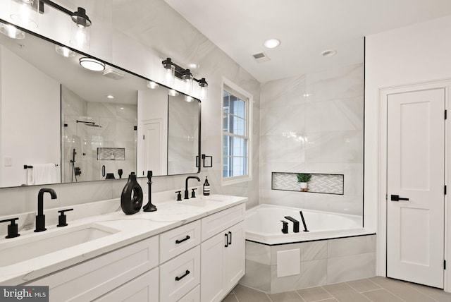 bathroom featuring vanity, tile patterned flooring, and plus walk in shower