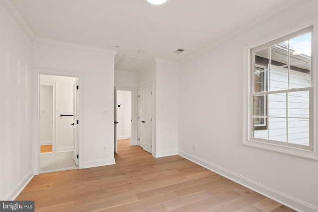 empty room with ornamental molding and light hardwood / wood-style flooring