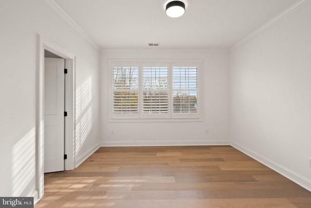 spare room featuring crown molding and light hardwood / wood-style flooring