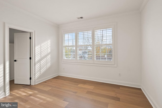 empty room featuring light hardwood / wood-style flooring, plenty of natural light, and ornamental molding