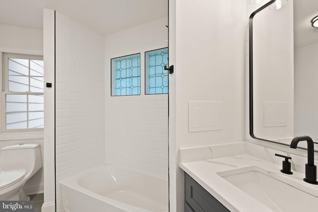 full bathroom featuring vanity, toilet, and tiled shower / bath