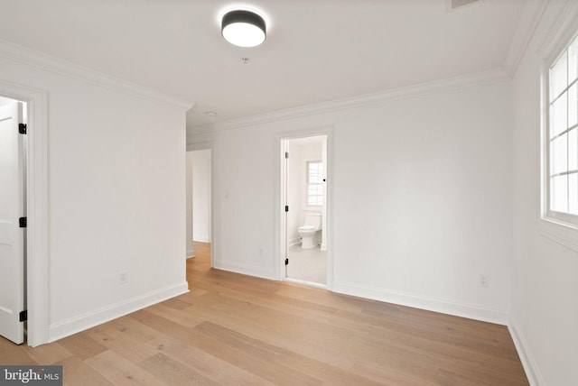 spare room with light hardwood / wood-style floors, a wealth of natural light, and ornamental molding