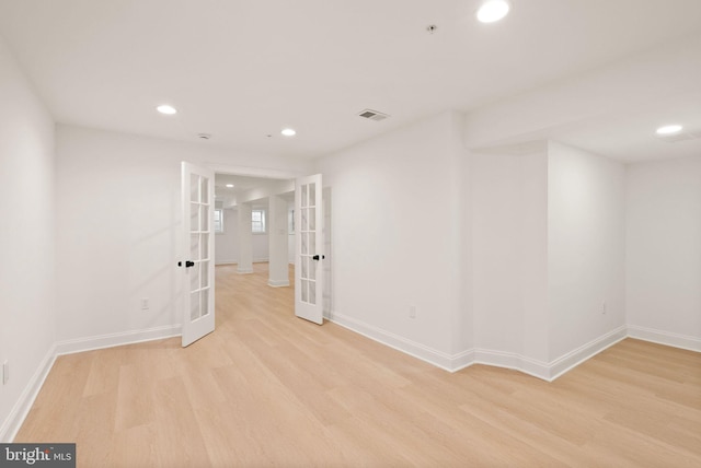 spare room featuring french doors and light hardwood / wood-style floors