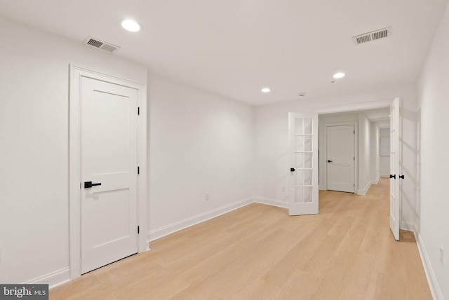 spare room featuring light hardwood / wood-style flooring and french doors