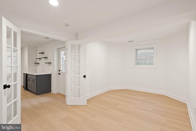 unfurnished room with french doors and light wood-type flooring