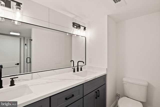 bathroom with vanity, toilet, and a shower with door