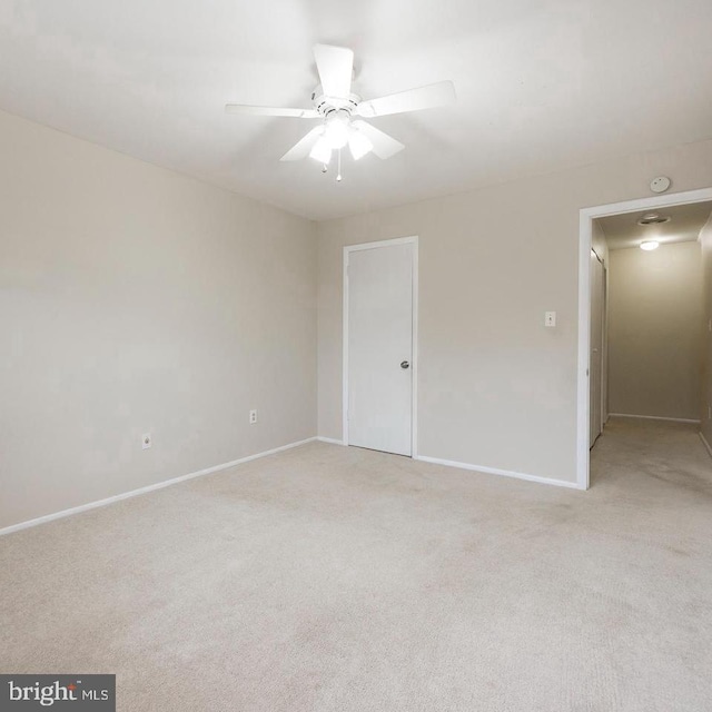 carpeted spare room with ceiling fan