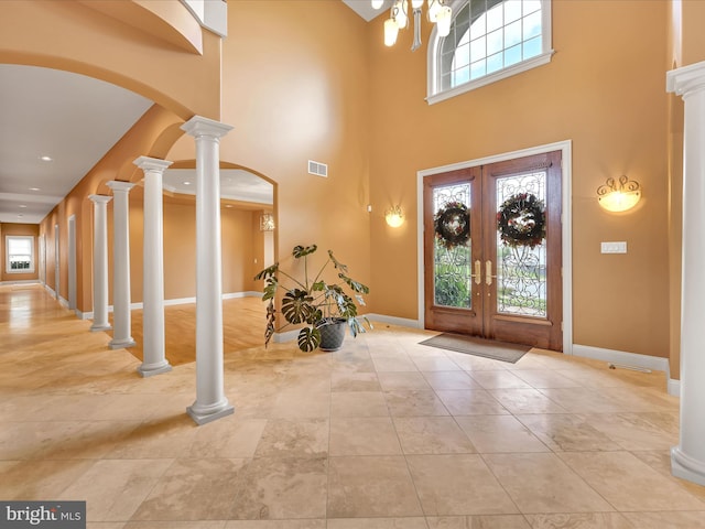 entrance foyer with a towering ceiling, a wealth of natural light, and french doors