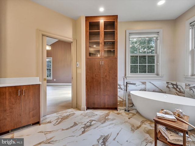 bathroom with vanity and a tub