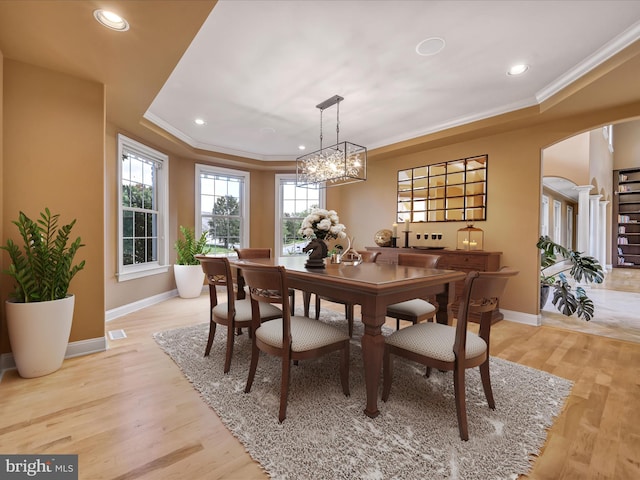 dining room featuring a chandelier, ornamental molding, and light hardwood / wood-style flooring