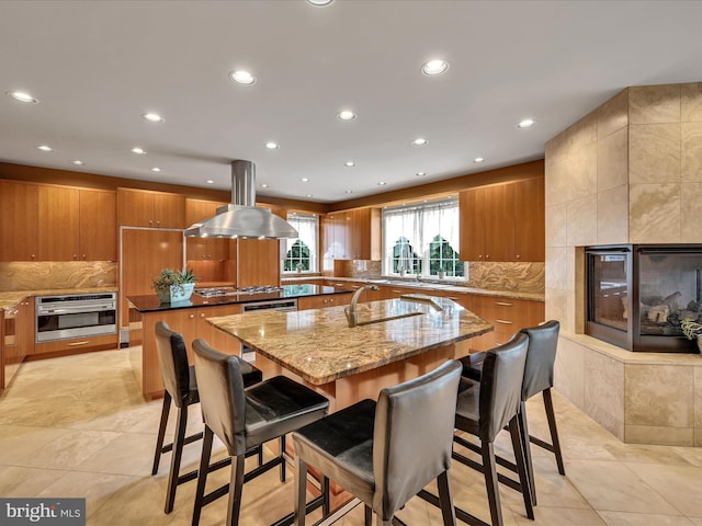 52 Violets Path, Elizabethtown, PA 17022 - kitchen with a center island with sink, island range hood, stainless steel oven, brown cabinets, and recessed lighting
