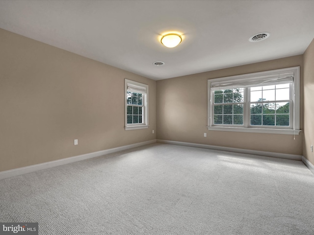 spare room with plenty of natural light and carpet floors