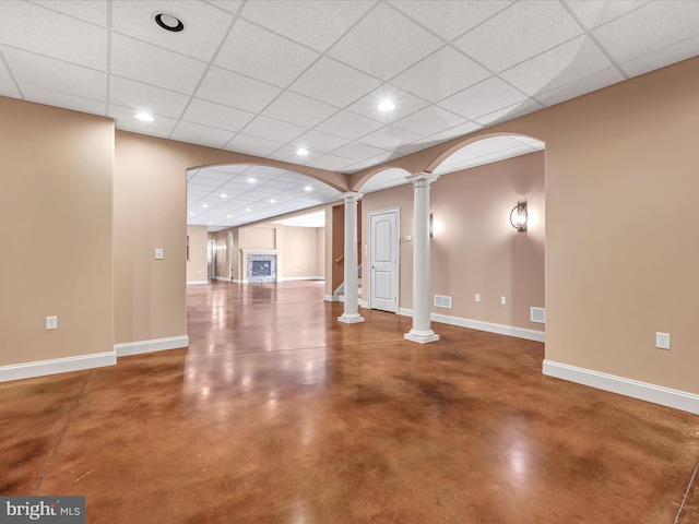 interior space with a paneled ceiling and concrete flooring