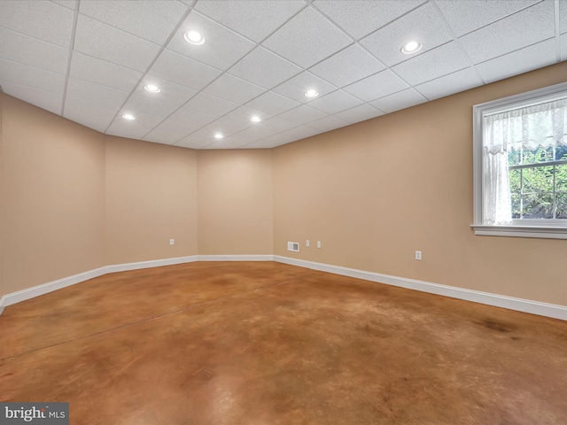 empty room with concrete flooring and a drop ceiling