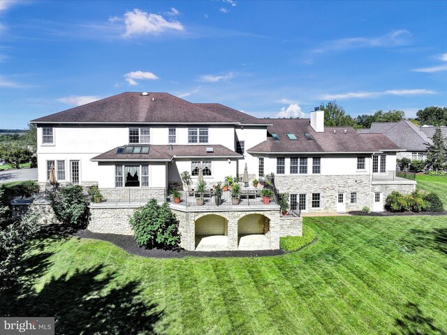 52 Violets Path, Elizabethtown, PA 17022 - rear view of house with stone siding, a lawn, a chimney, a patio, and stucco siding