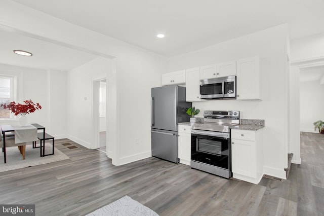 kitchen featuring dark hardwood / wood-style flooring, stainless steel appliances, and white cabinets