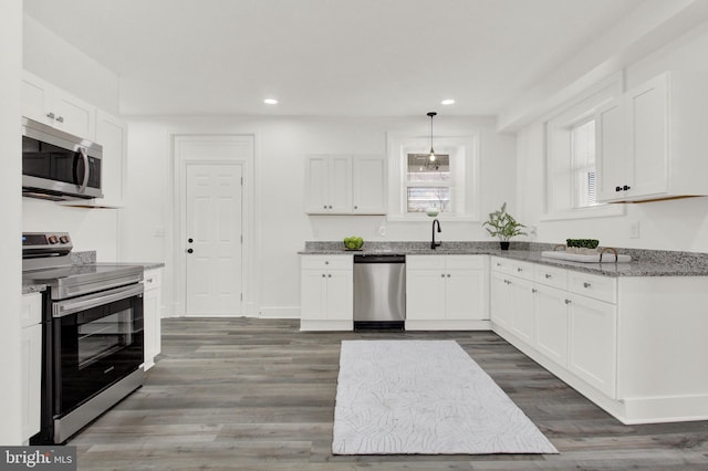 kitchen featuring white cabinets, appliances with stainless steel finishes, and dark wood-type flooring