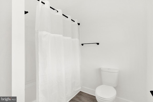 bathroom featuring walk in shower, toilet, and hardwood / wood-style flooring