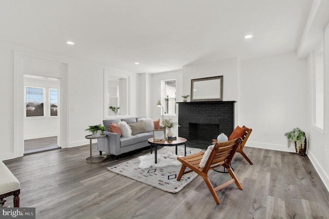 living room with hardwood / wood-style flooring and a brick fireplace