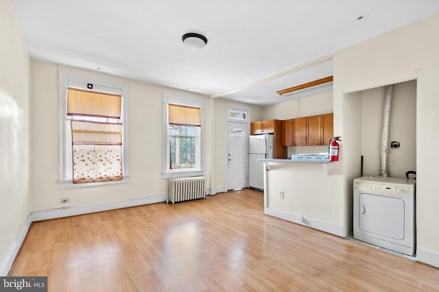 kitchen featuring white fridge, radiator, washer / clothes dryer, and light wood-type flooring