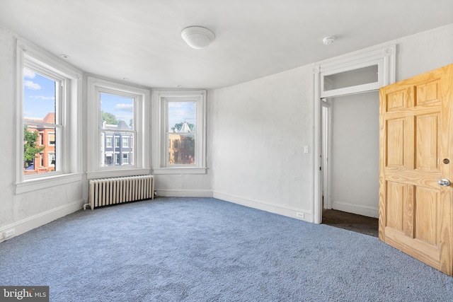 unfurnished bedroom featuring dark colored carpet and radiator