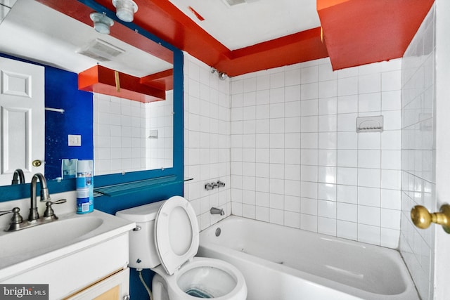 full bathroom with vanity, tiled shower / bath combo, and toilet