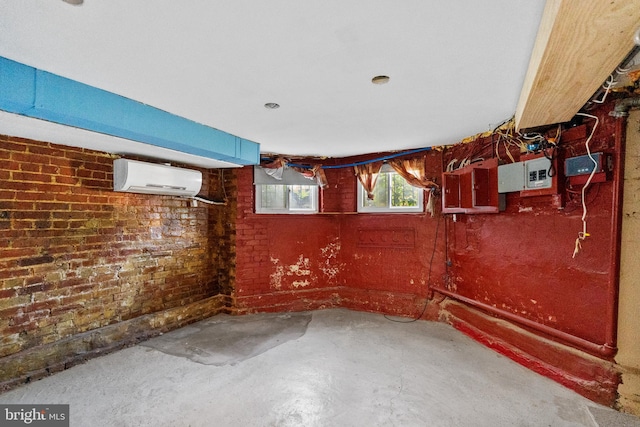 basement featuring electric panel, a wall mounted AC, and brick wall