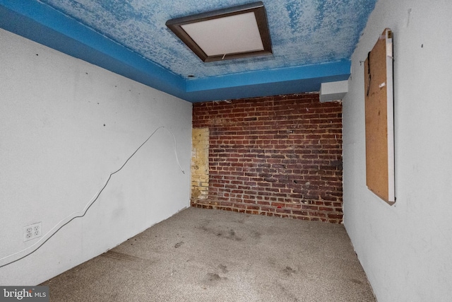 unfurnished room with carpet floors and brick wall