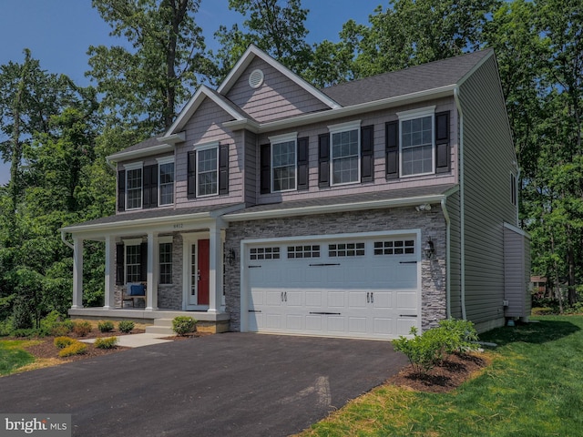 view of front of house featuring a front lawn, a porch, and a garage