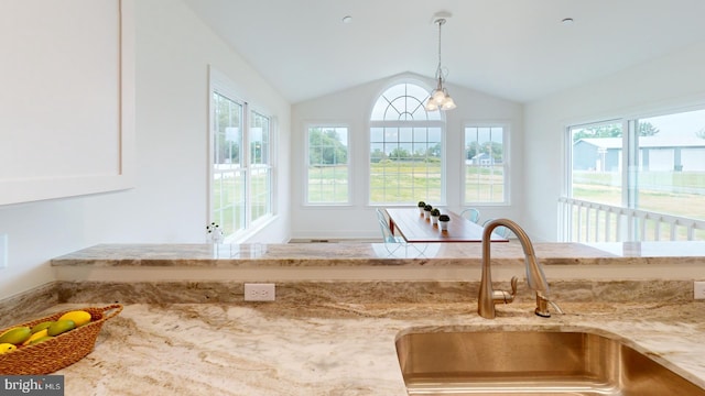 interior details with pendant lighting, light stone countertops, and sink