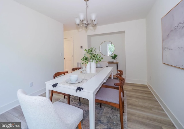 dining area featuring light hardwood / wood-style flooring and a notable chandelier