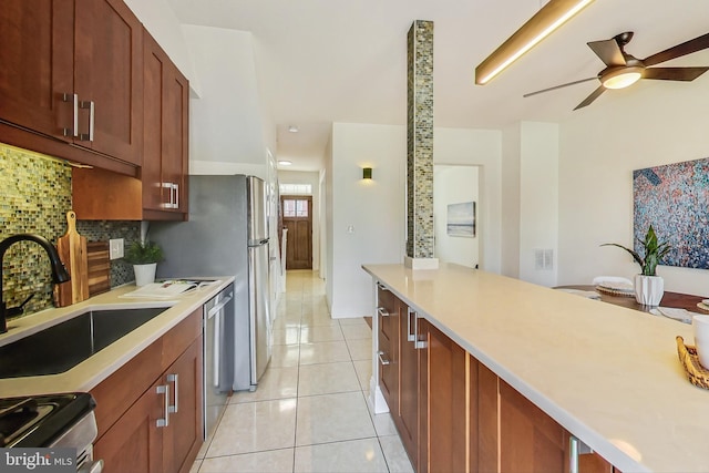 kitchen with tasteful backsplash, sink, stainless steel appliances, light tile patterned floors, and ceiling fan