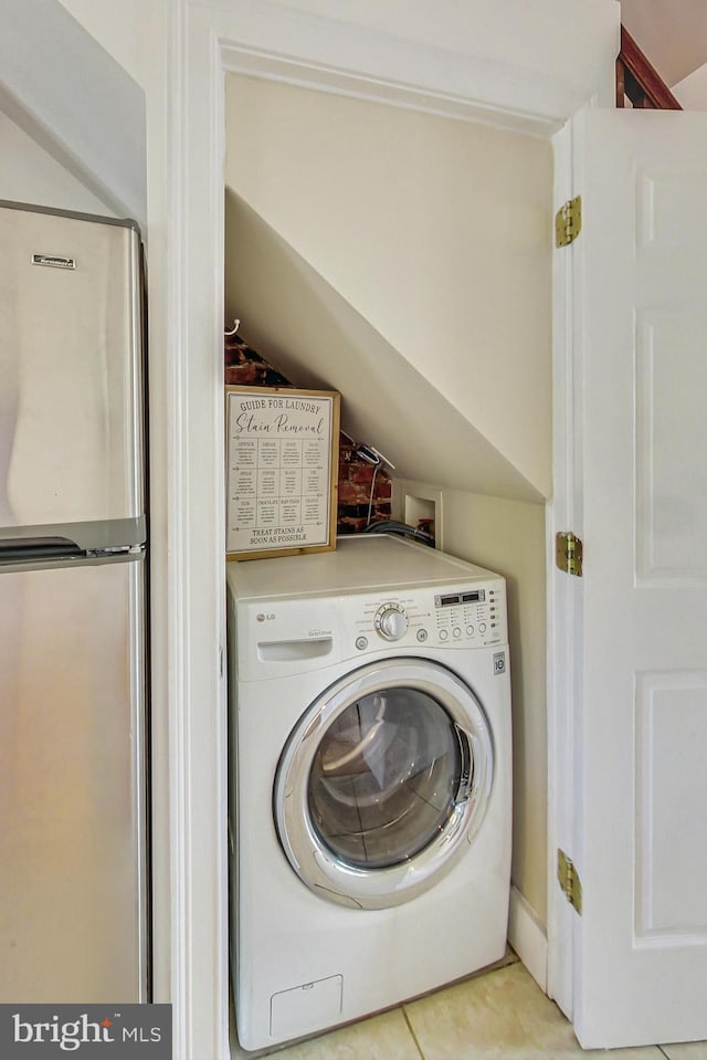 laundry area with light tile patterned floors and washer / dryer