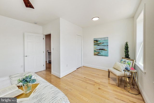 living area featuring wood-type flooring and ceiling fan