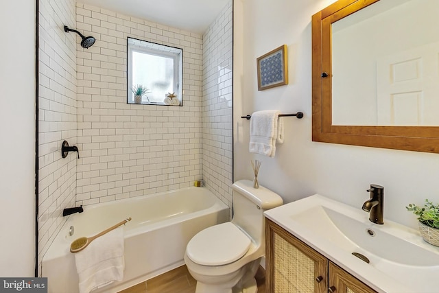 full bathroom with vanity, tiled shower / bath combo, and toilet