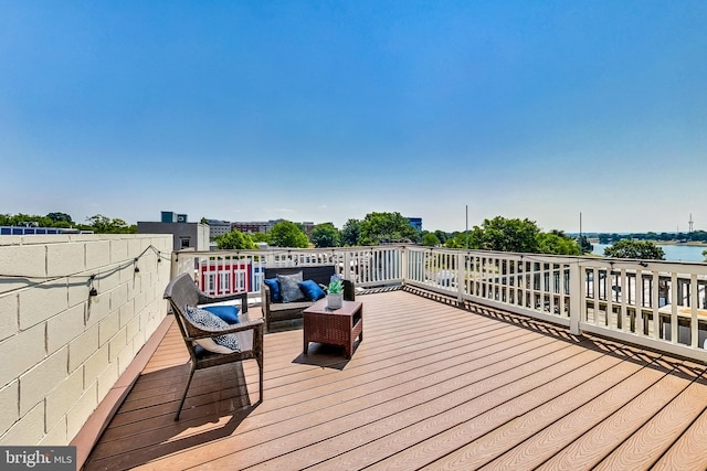 wooden deck with an outdoor hangout area and a water view