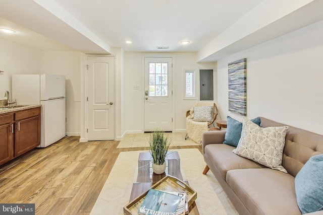 living room with light hardwood / wood-style floors and sink