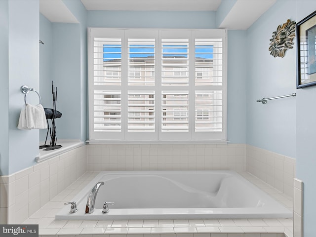 bathroom featuring a relaxing tiled tub and plenty of natural light