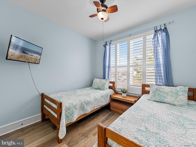 bedroom with ceiling fan and dark wood-type flooring