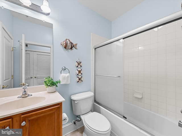 full bathroom with enclosed tub / shower combo, vanity, and toilet