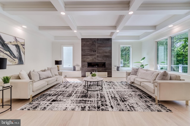 living room featuring a fireplace, light wood-type flooring, beamed ceiling, and coffered ceiling