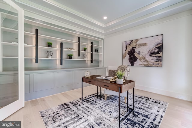 office space with wood-type flooring and a tray ceiling