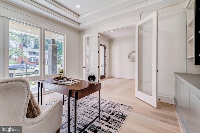 office with ornamental molding, light hardwood / wood-style flooring, and french doors