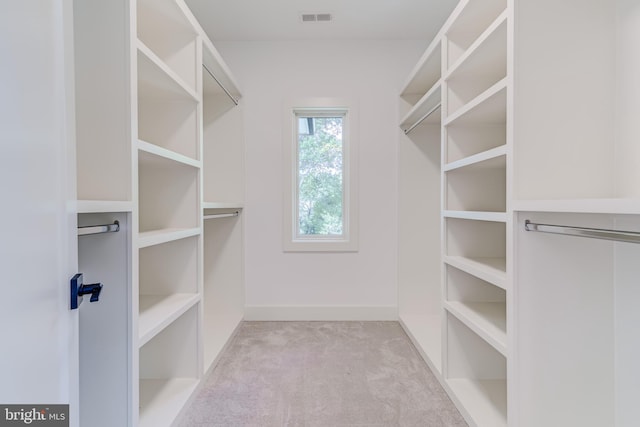 walk in closet featuring light colored carpet